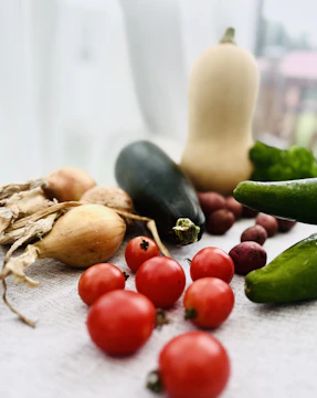 A crisp morning shot of fresh vegetables laid out on a rustic wooden table with soft natural light.