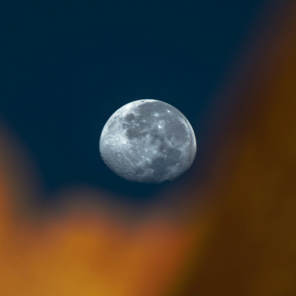 una luna llena vista a través de las nubes en el cielo nocturno