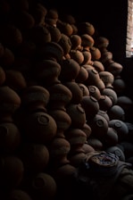 A serene studio corner with natural light illuminating clay pots in various stages of completion.