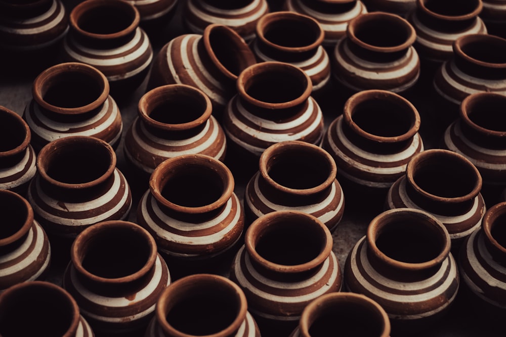 a bunch of brown and white vases stacked on top of each other