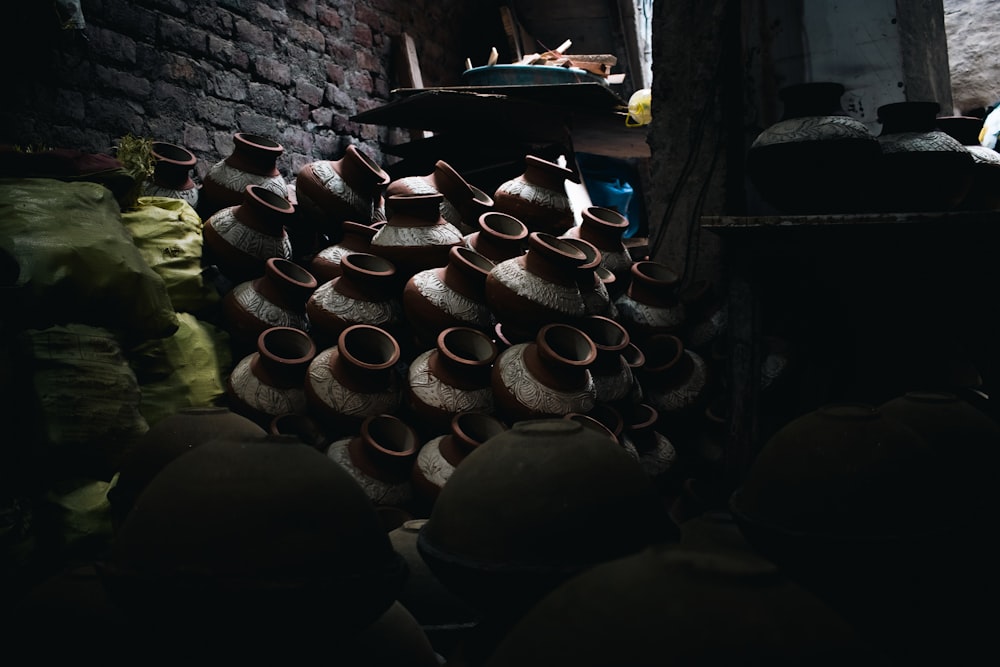 a room filled with lots of pots and a brick wall