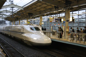 A bustling train platform at sunrise with passengers boarding a sleek modern train