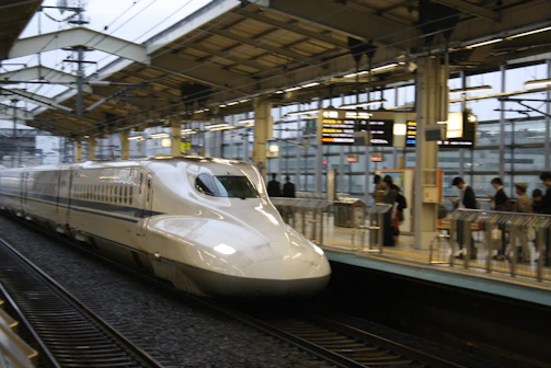 A panoramic view of a modern European high-speed rail station bustling with travelers.