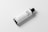 A bottle with a minimalist design labeled 'OIL BOTTLE MOCKUP' rests on a plain white surface. The bottle is cylindrical with a black cap and white label featuring black text and a QR code.