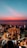 A breathtaking sunset over Uluwatu Temple with silhouettes of dancers performing the Kecak dance.