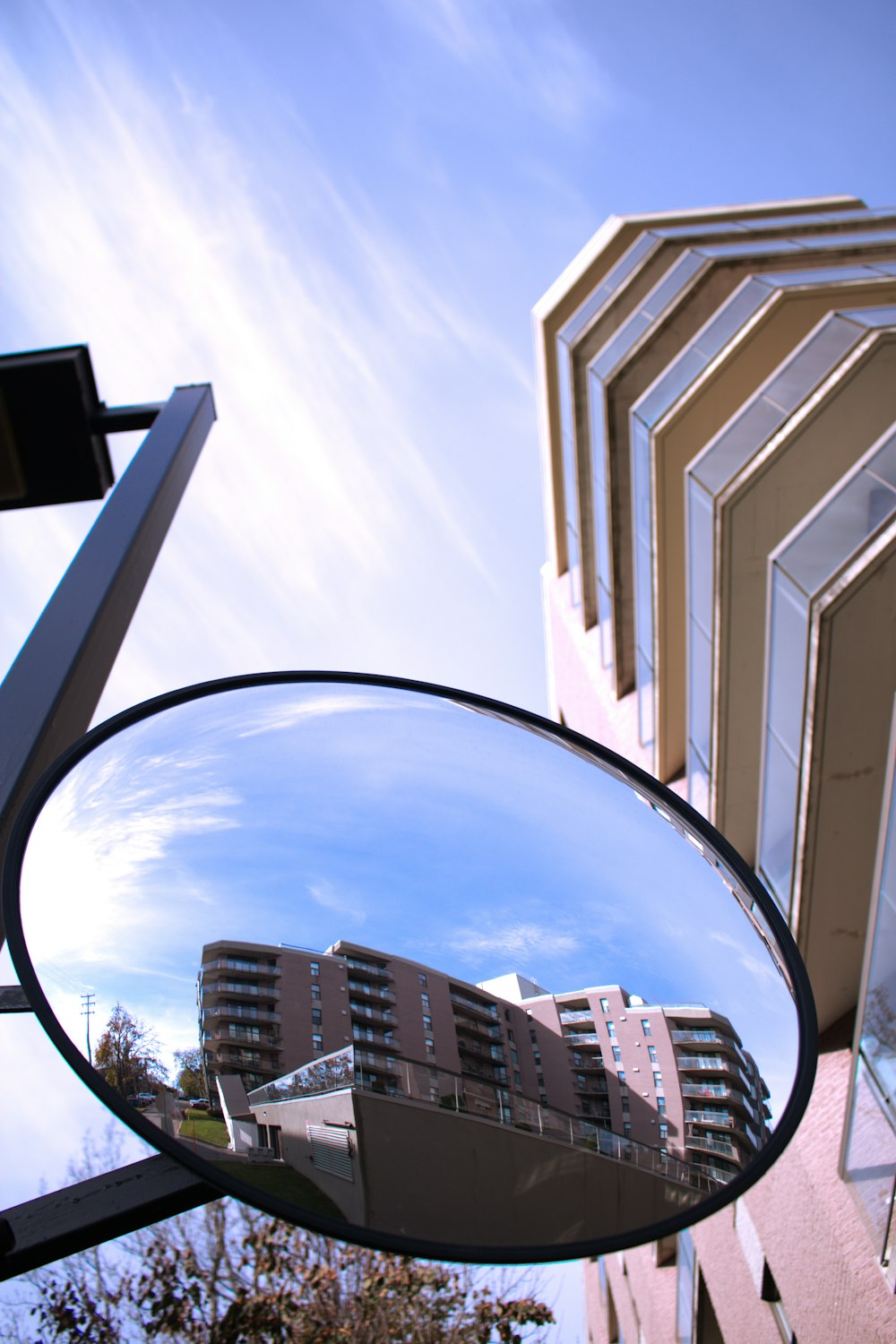 uno specchietto retrovisore su un edificio con un edificio sullo sfondo