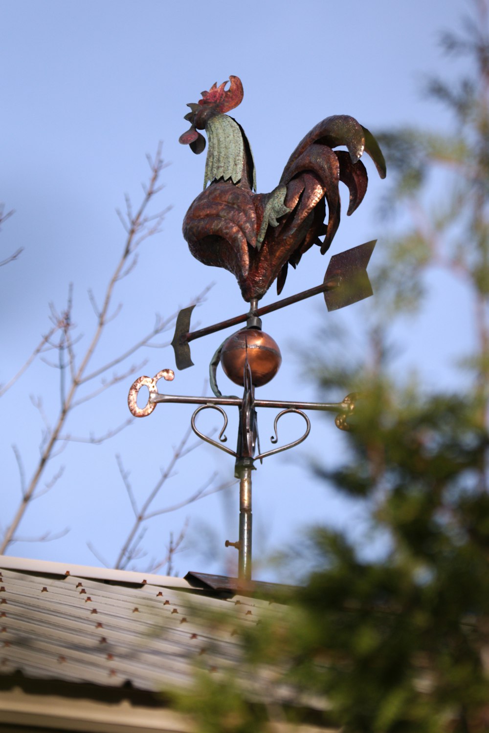 a rooster weather vane on top of a roof
