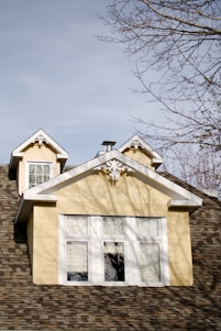 a yellow house with a clock on the top of it