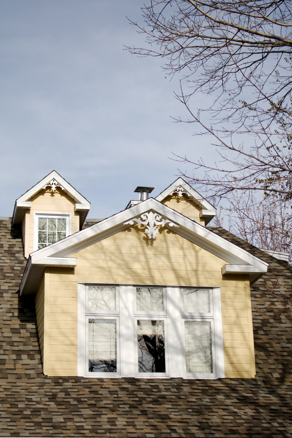 a yellow house with a clock on the top of it