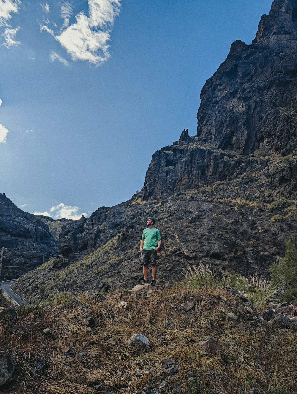 eine Person, die auf einem Hügel mit einem Berg im Hintergrund steht