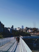a group of people walking across a bridge