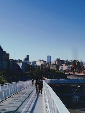 a group of people walking across a bridge