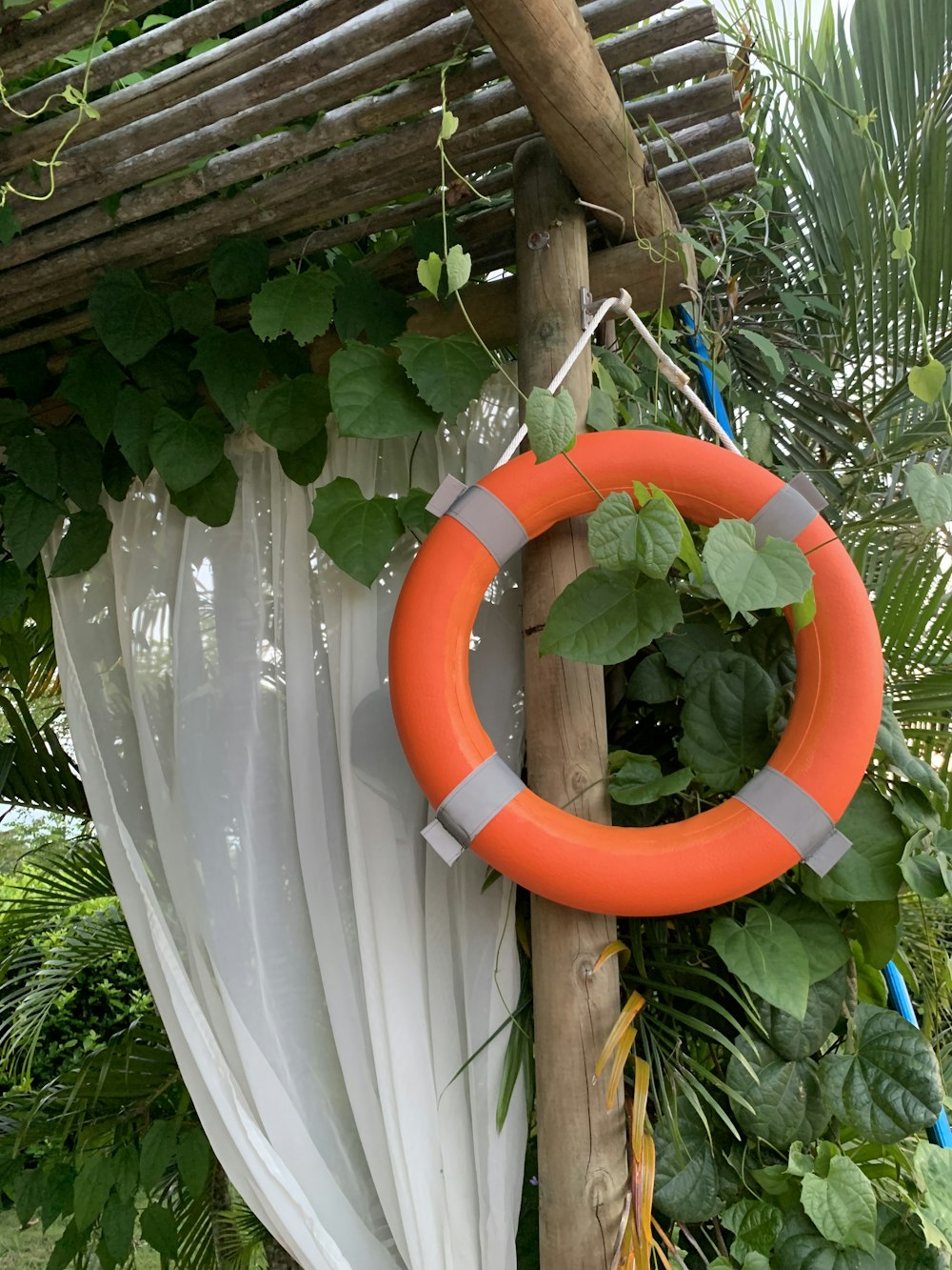 an orange life preserver hanging from a wooden pole