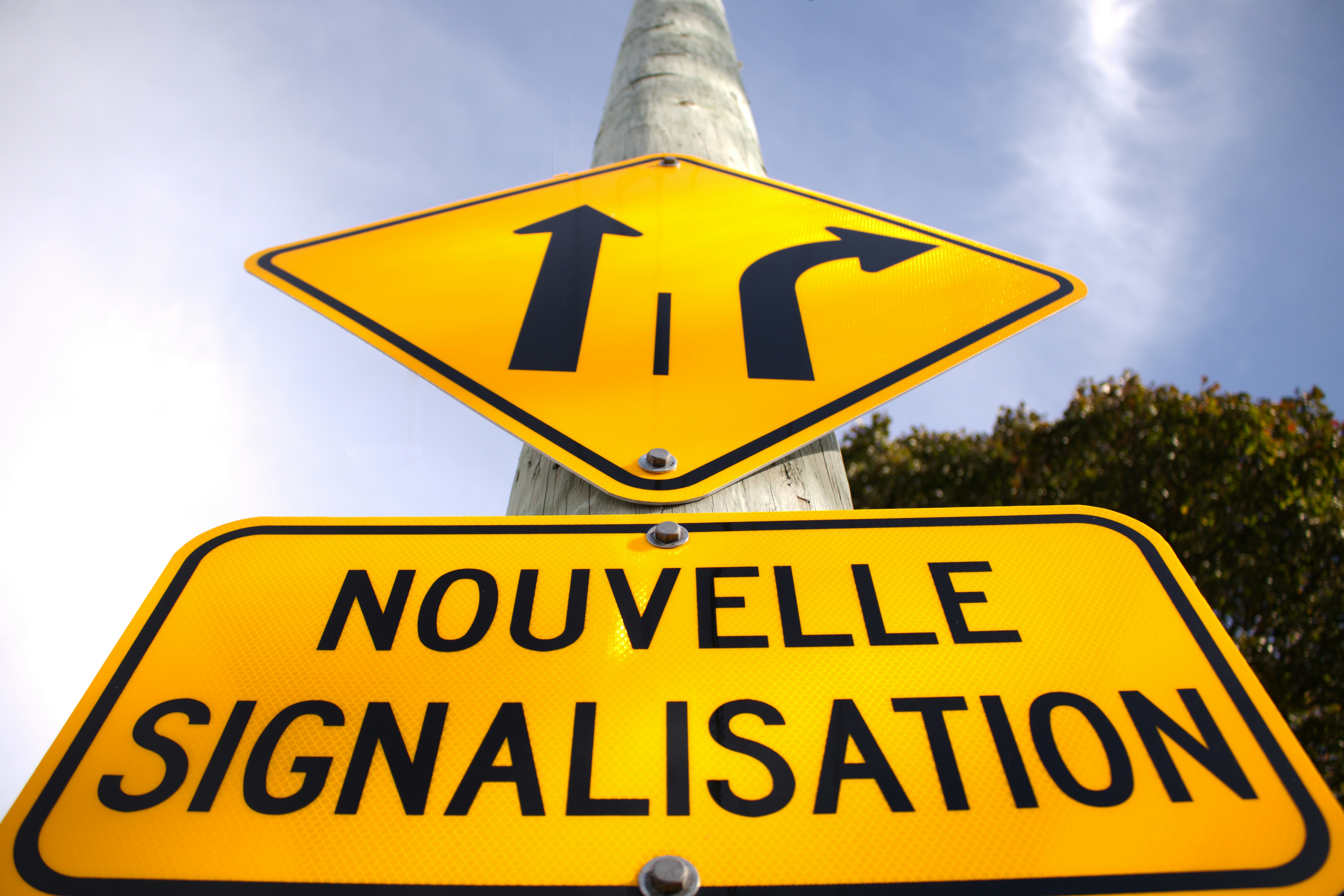 a yellow street sign sitting on top of a metal pole