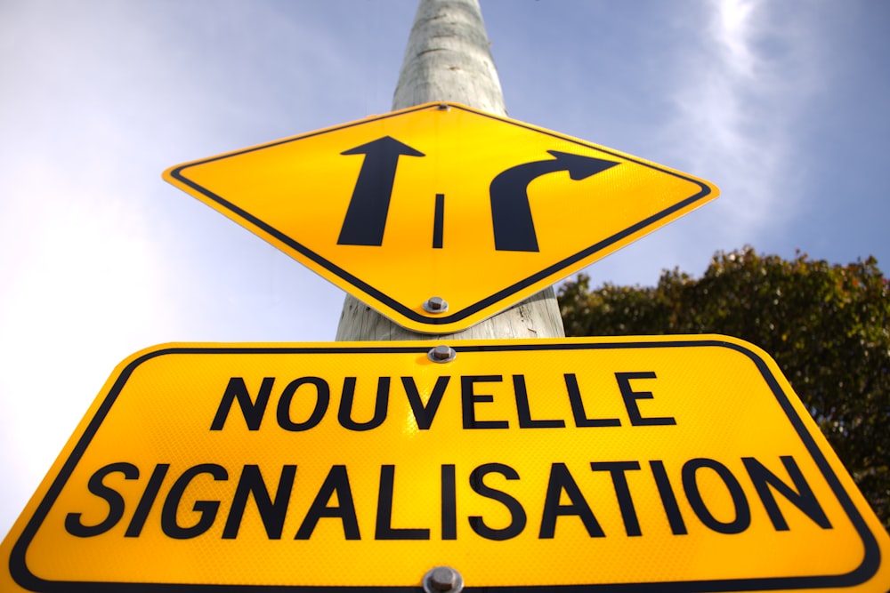 a yellow street sign sitting on top of a metal pole