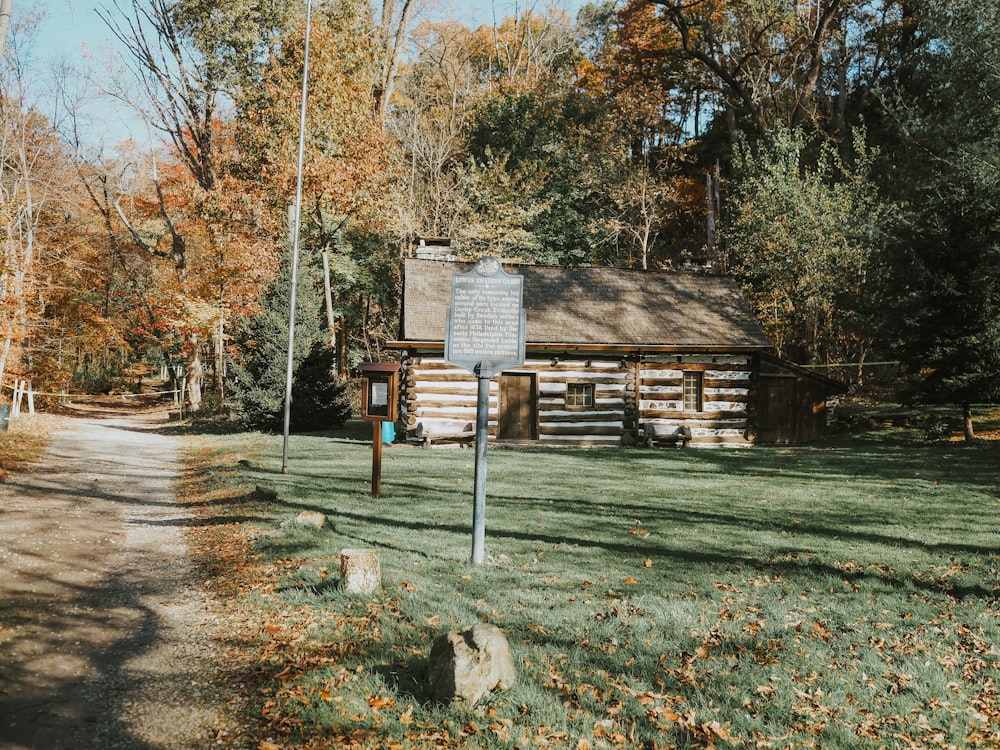 a log cabin in the woods near a road