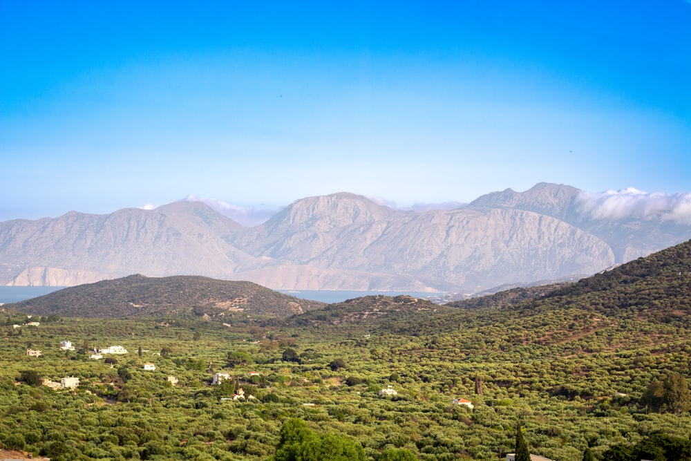 a scenic view of a mountain range with a lake in the foreground