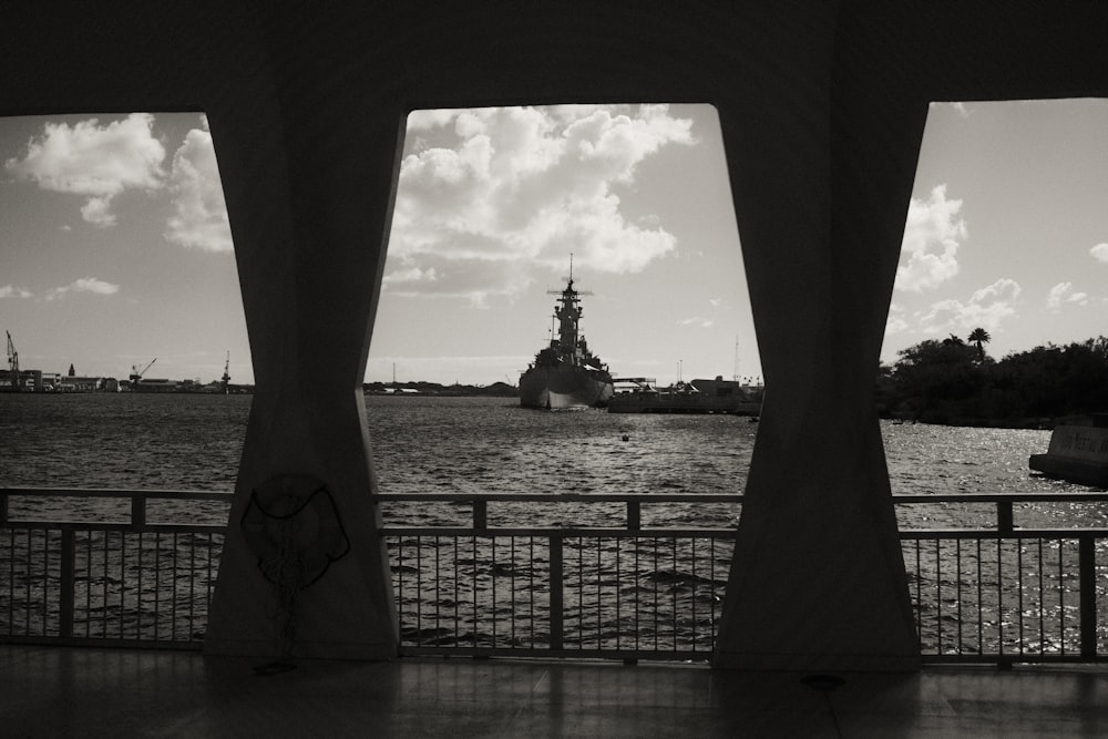 a large ship is in the water near a fence