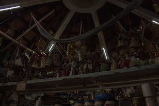 Handcrafted ponchos and ceramics displayed against a backdrop of carved wooden beams and stone walls.