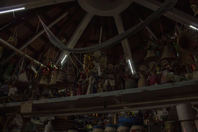 Handcrafted ponchos and ceramics displayed against a backdrop of carved wooden beams and stone walls.