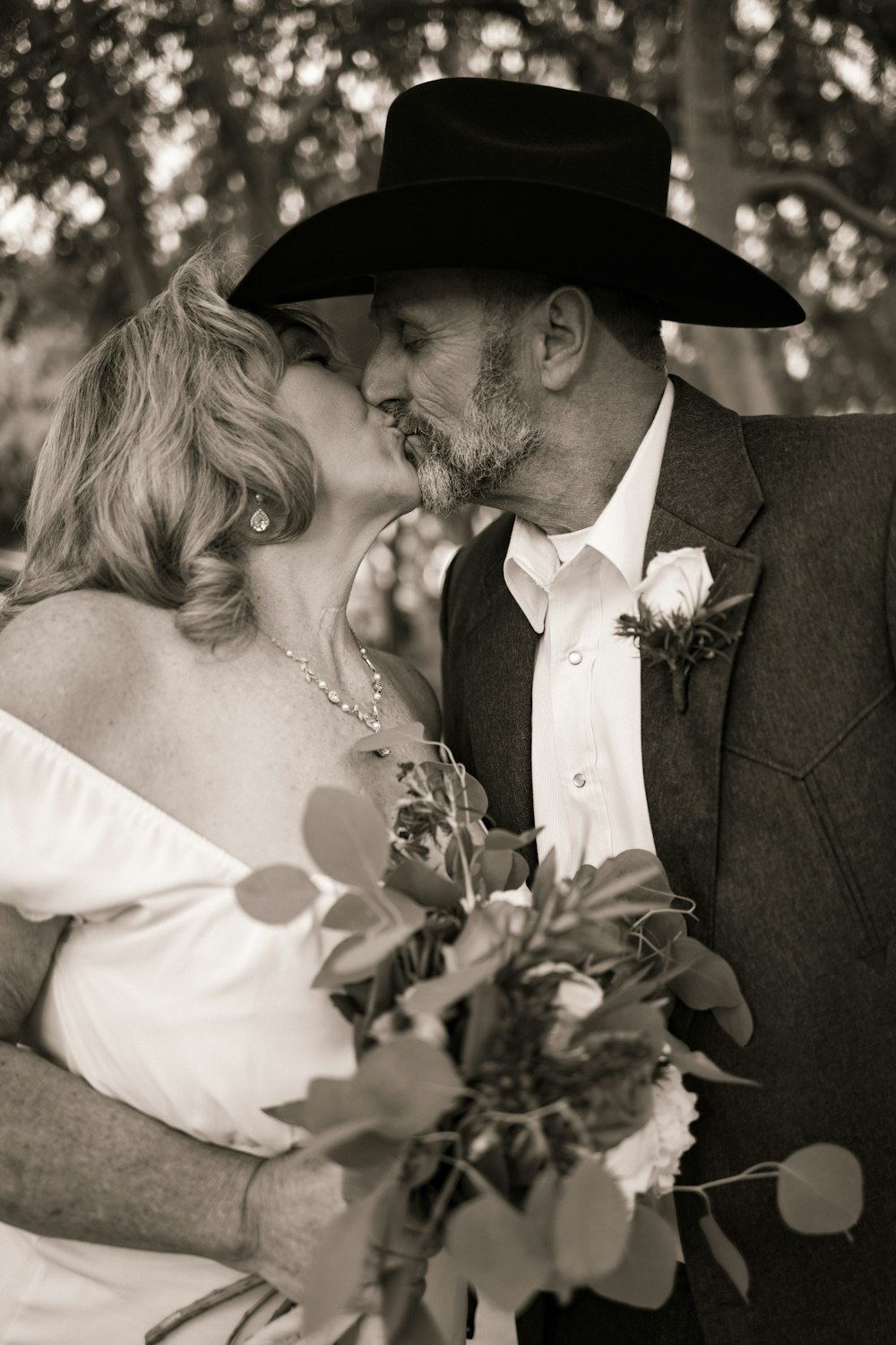 a man in a cowboy hat kissing a woman