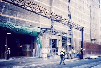a group of people standing outside of a building under construction