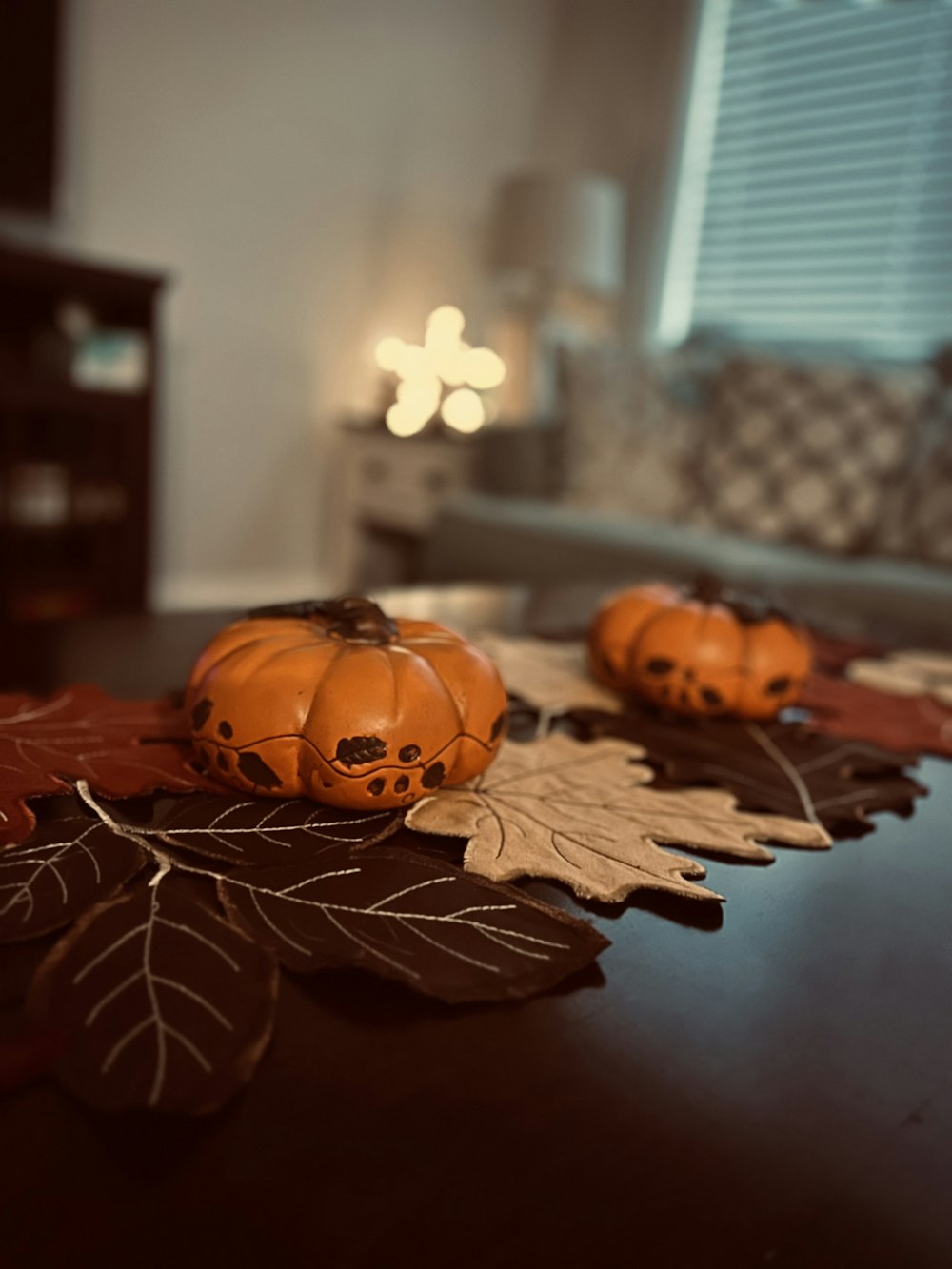 a wooden table topped with pumpkins and leaves