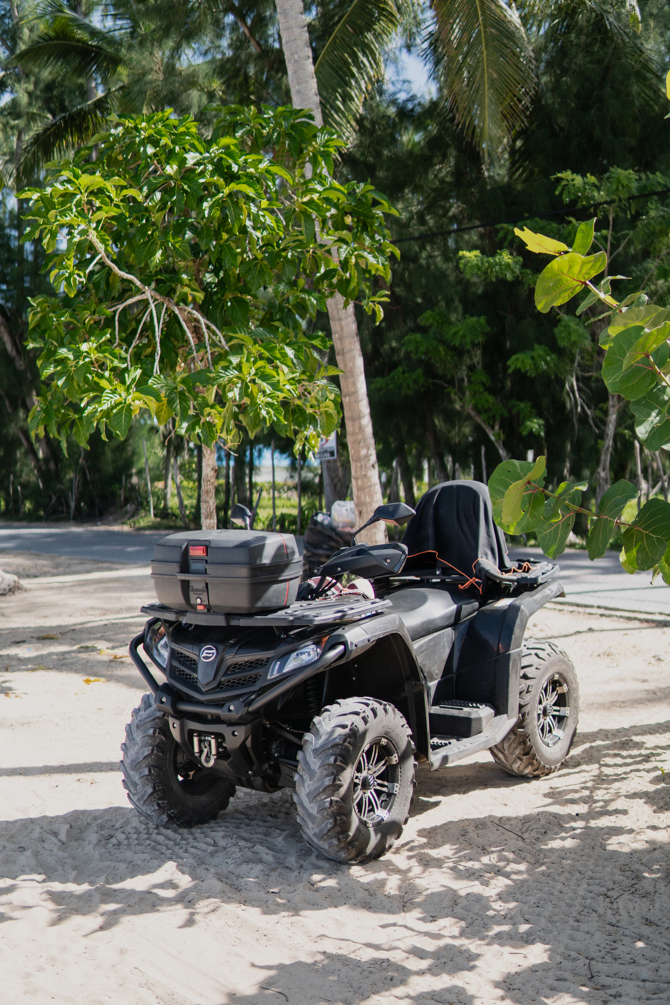 A quad parked on the sand at the edge of the town
