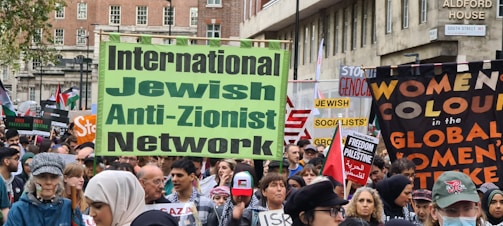 A peaceful rally of allies holding signs against antisemitism in a city square.
