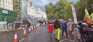 A lively street protest with colorful banners under a cloudy sky.