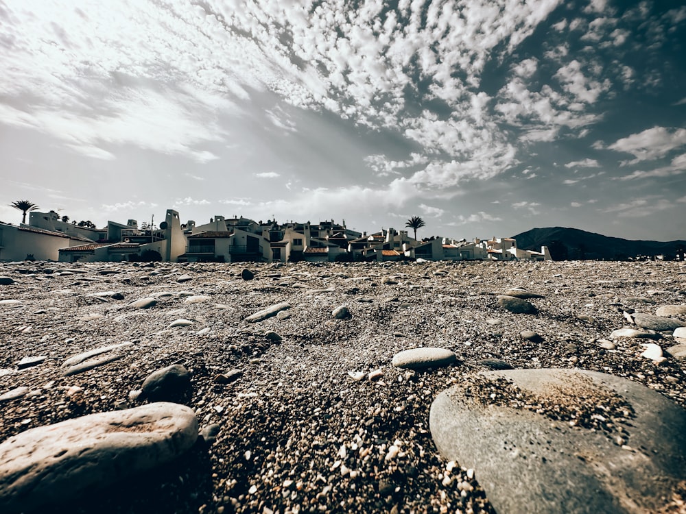 a rocky area with rocks and houses in the background