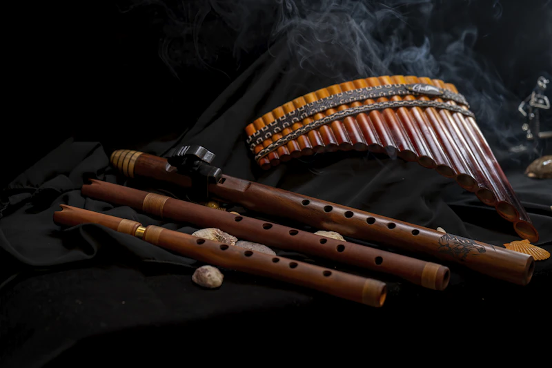 A collection of traditional flutes and woodwind instruments laid on a surface