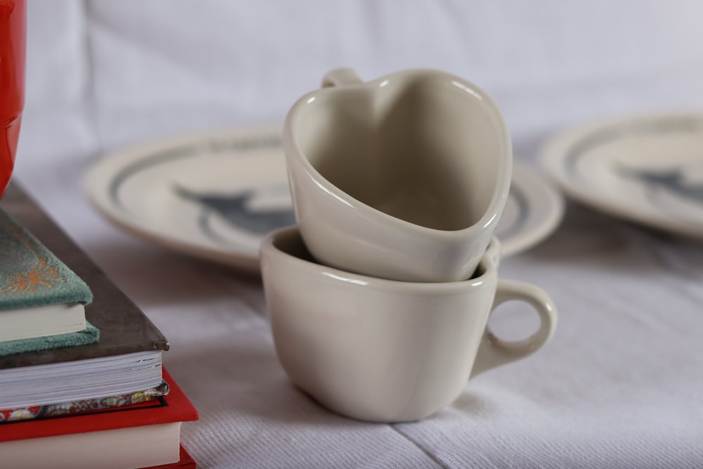 a stack of books sitting next to a stack of cups