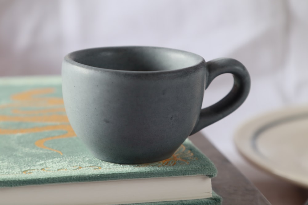 a coffee cup sitting on top of a stack of books