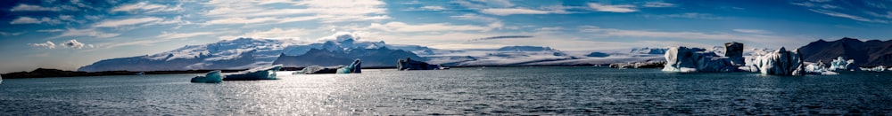 a group of icebergs floating on top of a body of water