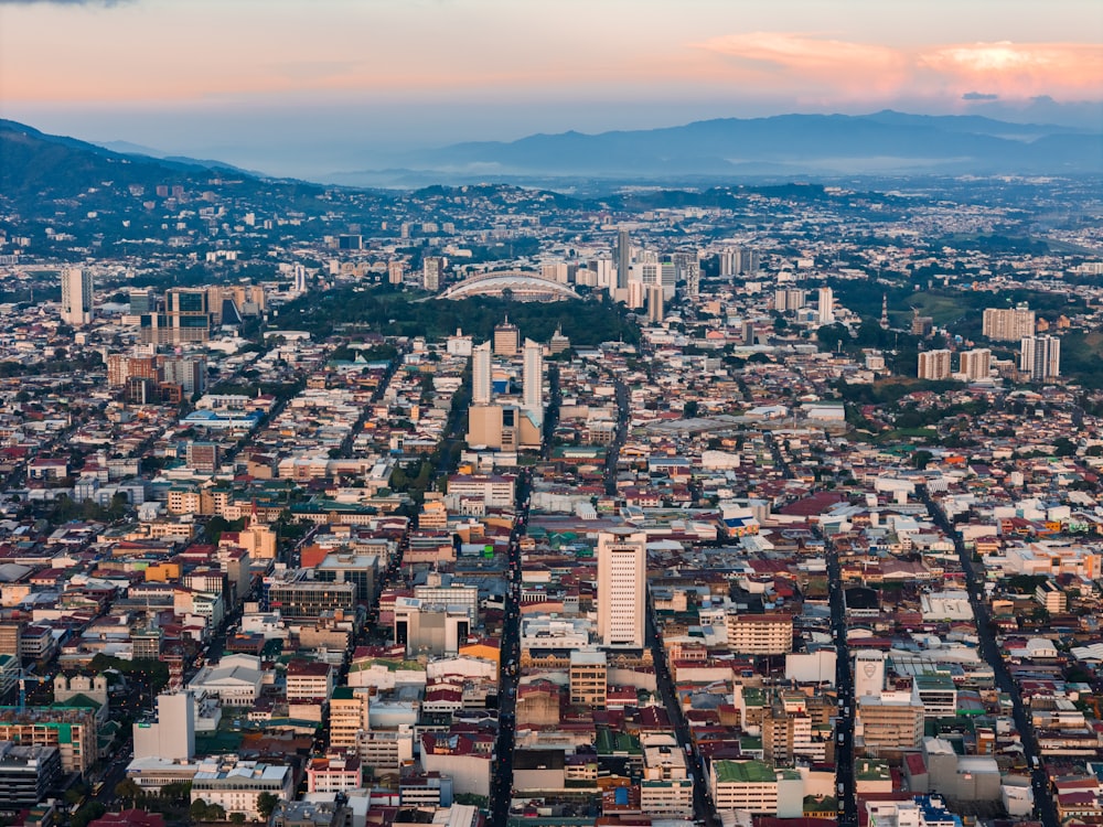 an aerial view of a city with mountains in the background