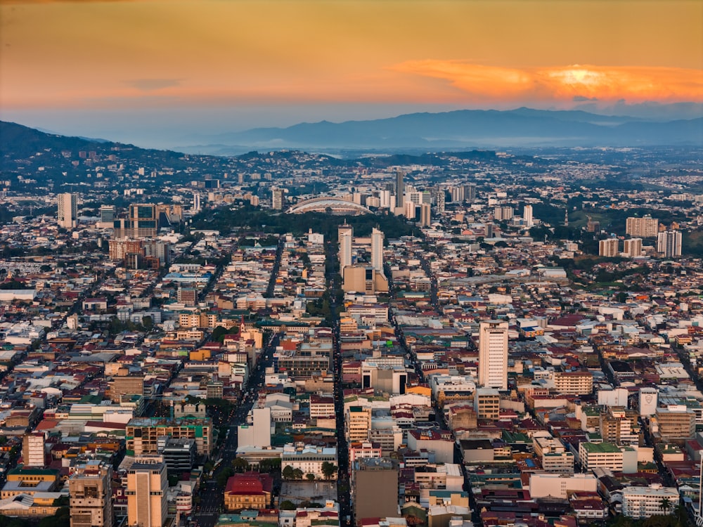 an aerial view of a city with mountains in the background