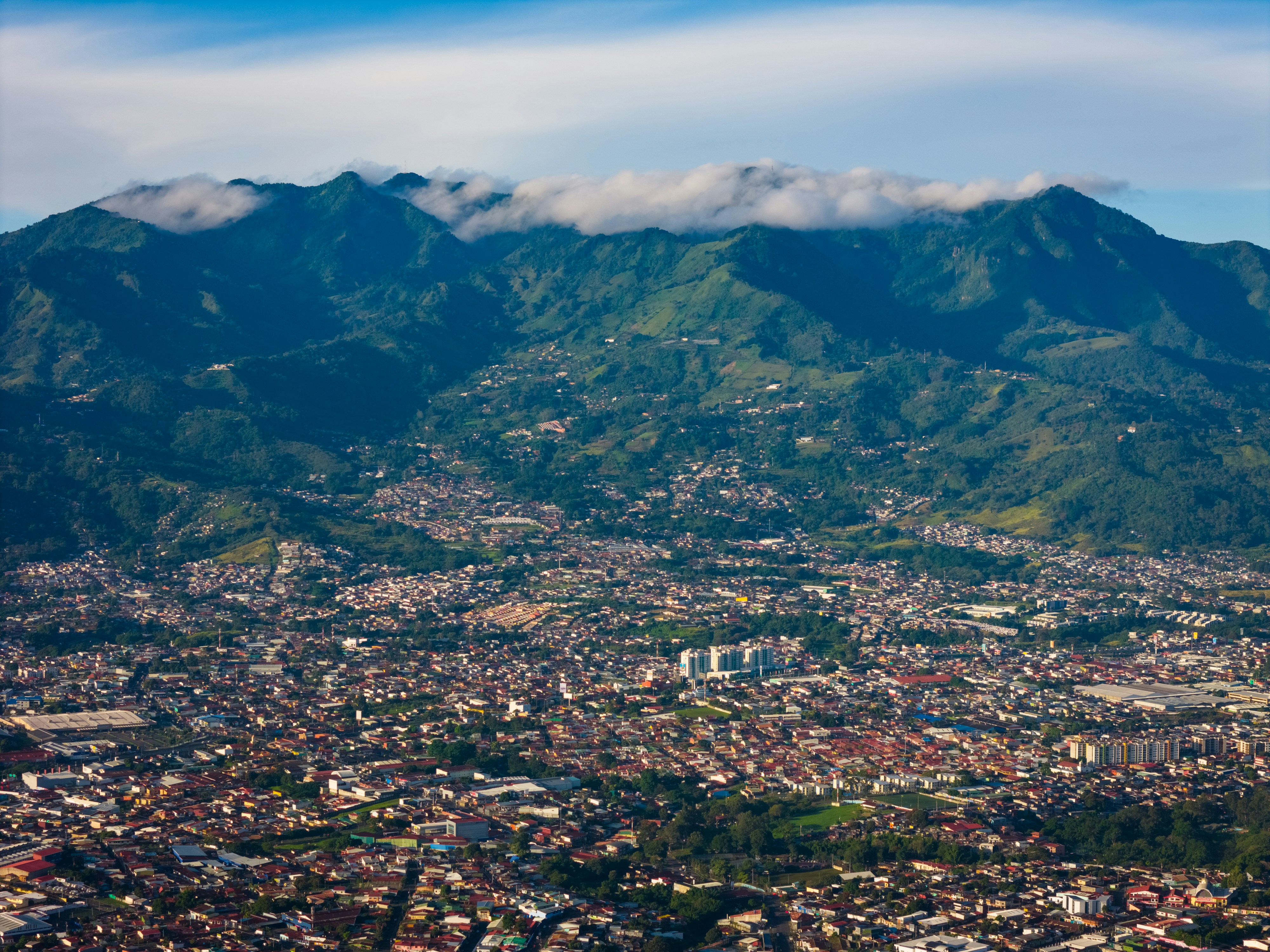 an aerial view of a city with mountains in the background, Aerial views of San José, Costa Rica in the morning