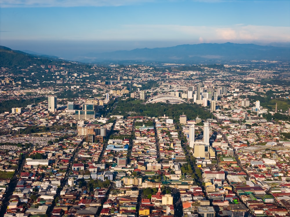 an aerial view of a city with mountains in the background