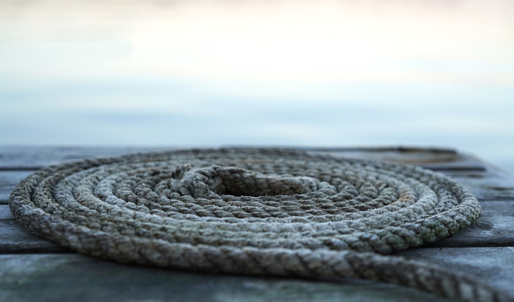 a rope is laying on a wooden dock
