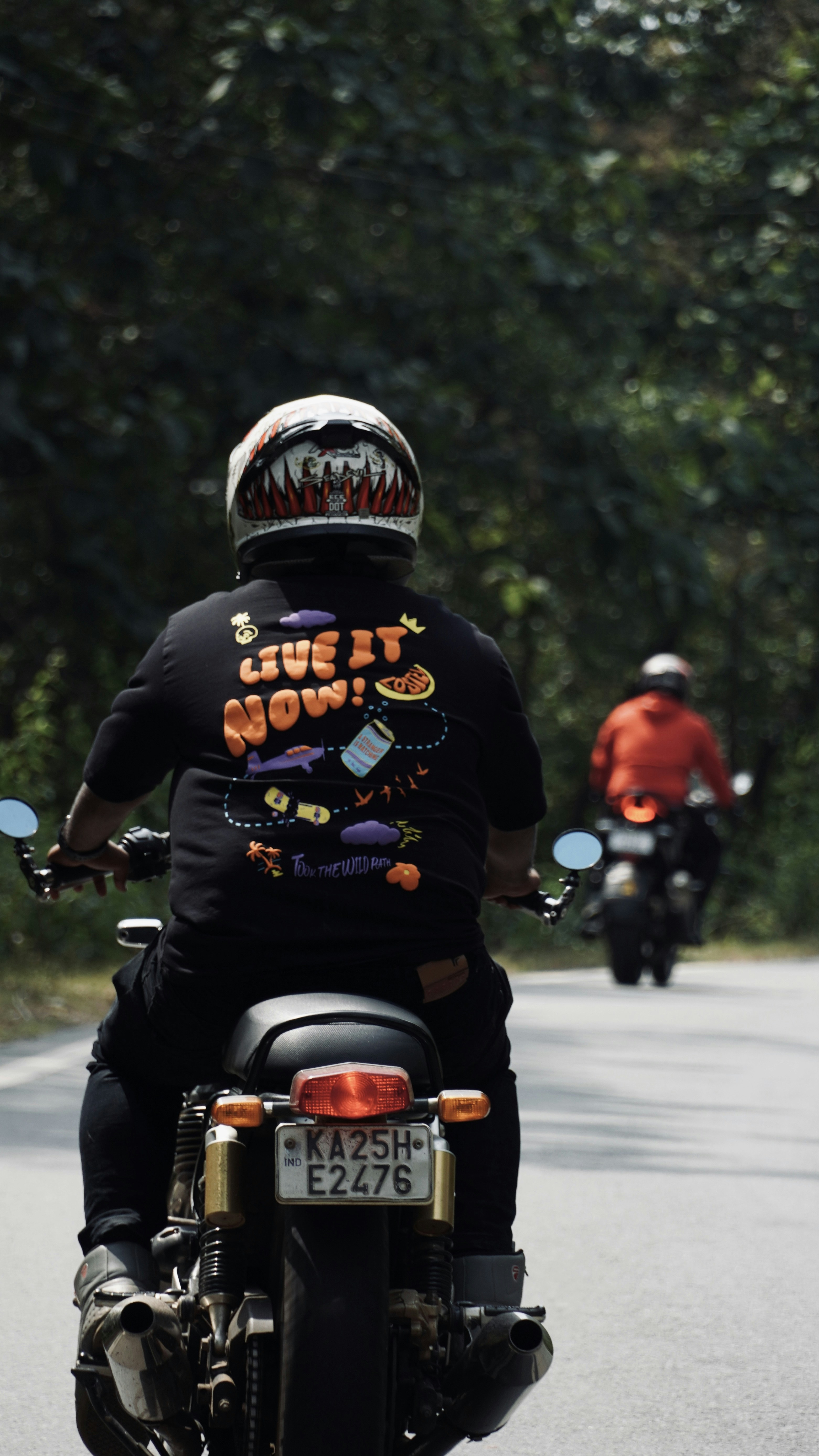 a couple of people riding motorcycles down a street