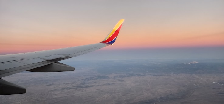 a view of the wing of an airplane at sunset