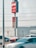 A Wendy's sign displaying slogans like 'QUALITY BURGERS SINCE 1969' and 'OPEN 24/7' is prominently shown. Several cars are parked nearby, with some moving in front of the sign. A stop sign is visible on the left side.