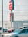 A Wendy's sign displaying slogans like 'QUALITY BURGERS SINCE 1969' and 'OPEN 24/7' is prominently shown. Several cars are parked nearby, with some moving in front of the sign. A stop sign is visible on the left side.