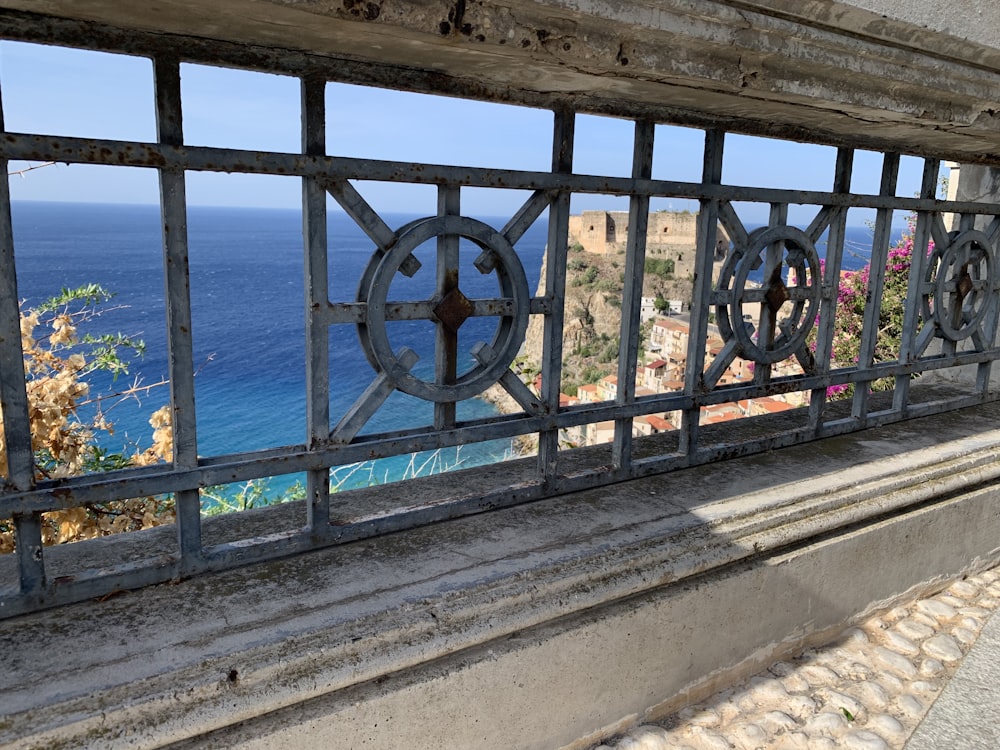 a view of a body of water through a metal fence