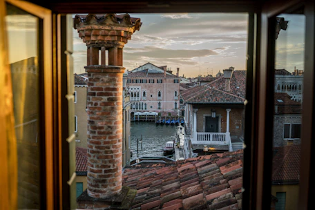 Charming Venetian canal view from a bright vacation home window.