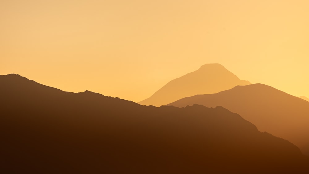 the silhouette of a mountain range at sunset