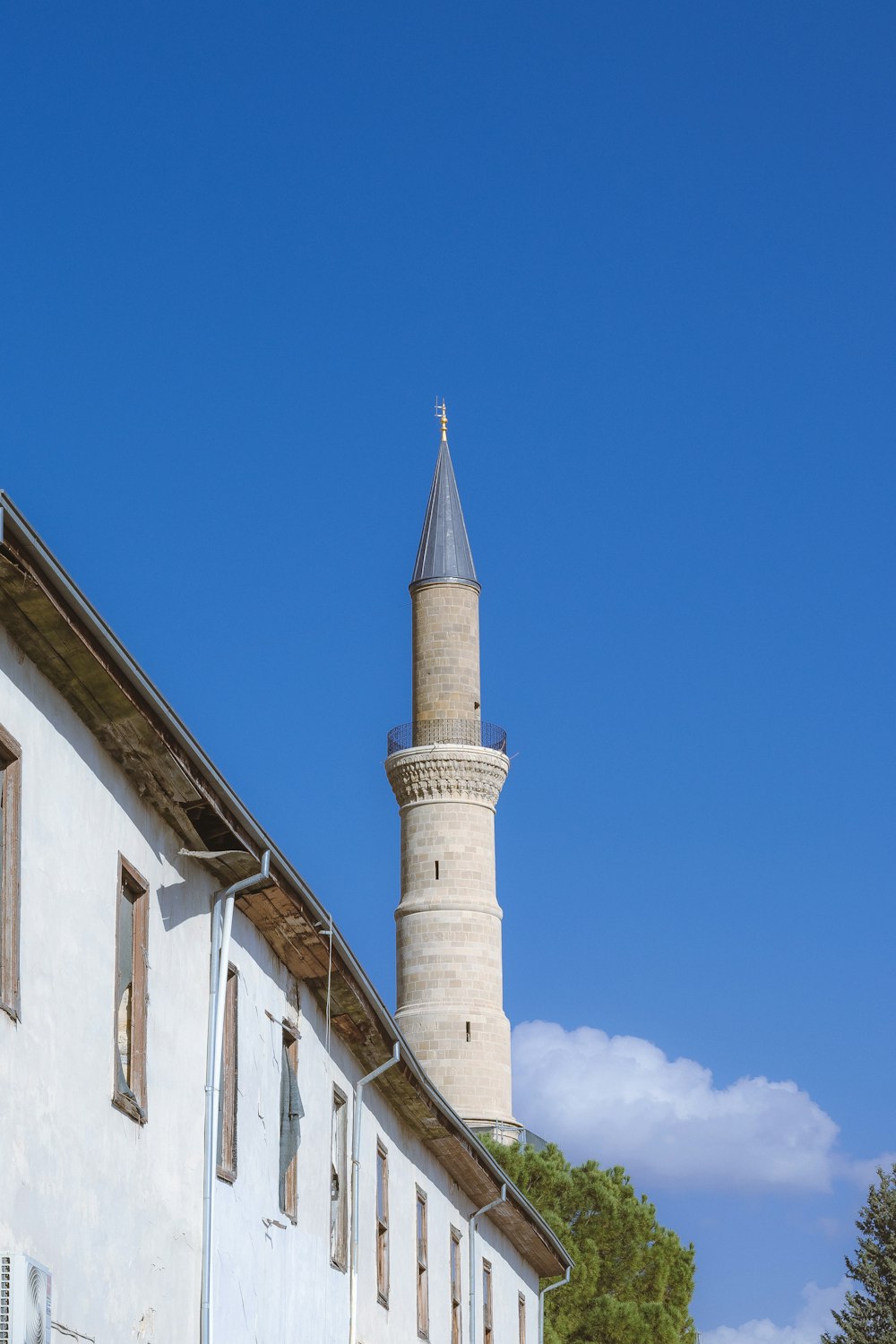 a tall white building with a clock tower in the background