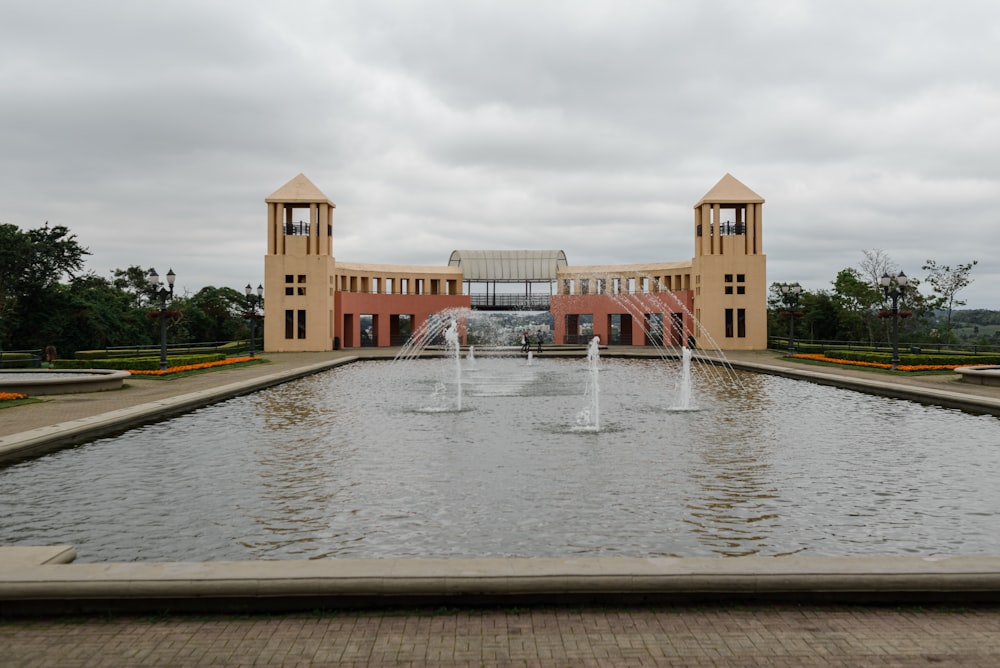 ein großes Gebäude mit einem Springbrunnen davor