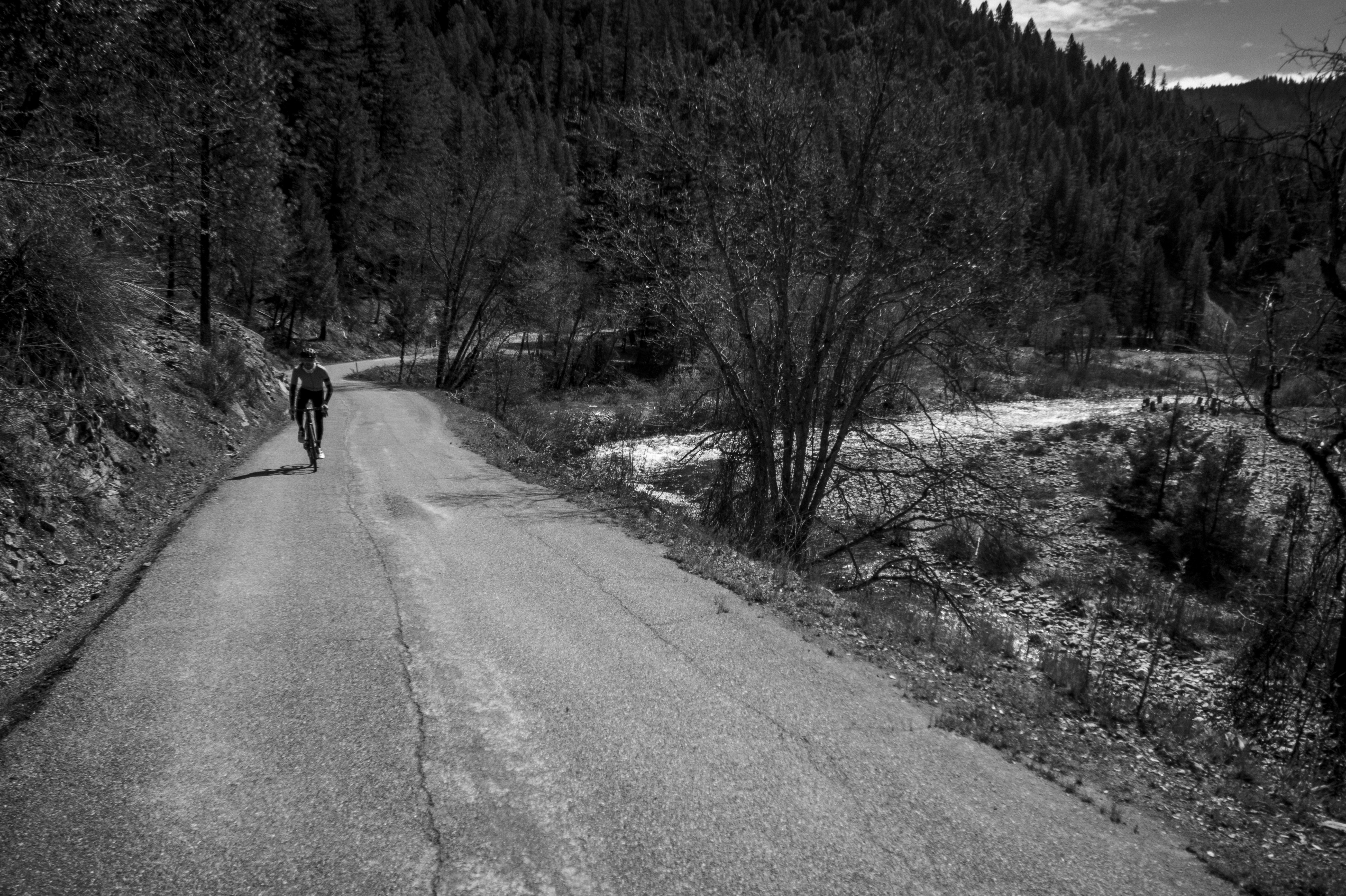 a black and white photo of a person walking down a road